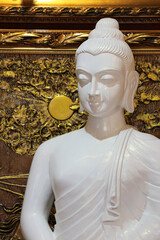 White marble meditating Buddha statue on dark background, serene and peaceful spiritual art