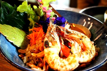 Thai Pomelo Salad with Grilled Shrimp and Edible Flowers, Traditional Miang in Ceramic Bowl with Herbal Garnishes