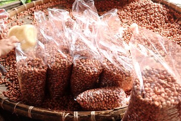 Shelled peanuts packed in clear plastic bags for sale. The peanuts are ready to use for cooking,...