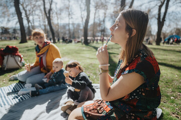 A family cherishing quality moments in a park, sharing joy and snacks under sunlight during a...
