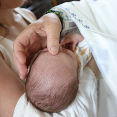The priest performs the rite of baptism of a newborn by placing his hand on the head.