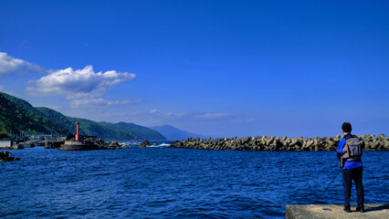 防波堤で魚を釣る人