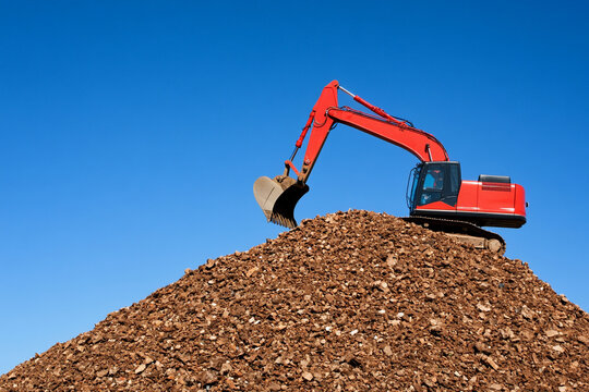 Heavy machinery clearing construction waste from a site