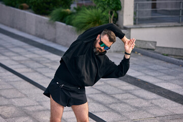Man in his middle years performing outdoor stretches for fitness on a sunny day. Concept of...
