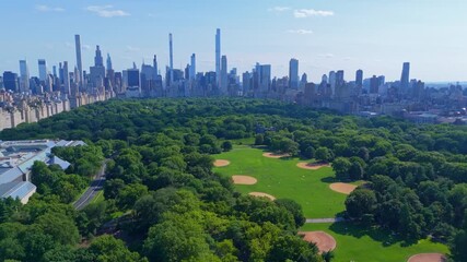 Central Park's The Great Lawn With Panoramic View Of Urban Skyscrapers In Distance. Manhattan, New York City, USA. wide aerial shot