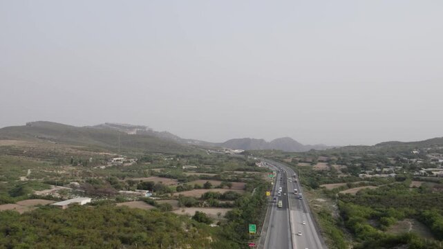 Aerial shot of M2 Motorway passing Simbal village and green fields near Kallar Kahar. Pakistan