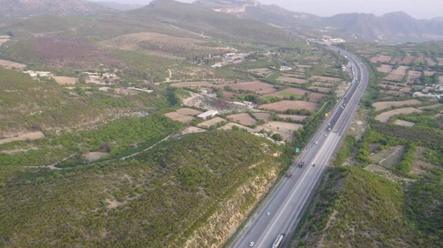 Aerial view of M2 Motorway winding through Kallar Kahar&rsquo;s mountains and patchwork fields. Pakistan