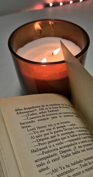 Aesthetic view of candle beside an open book.