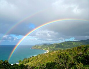 Rainbow spanning coastline under stormy clouds with verdant hills and blue ocean