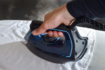 Detail of man ironing shirt on ironing board isolated background