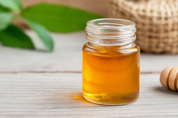 Jar of sweet honey with golden organic liquid in a natural setting for healthy breakfast
