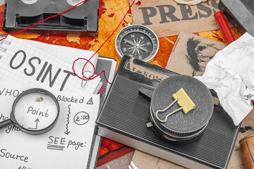 OSINT-themed creative workspace with vintage tools, handwritten notes, and press elements