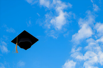 Graduation cap soaring through a bright blue sky with fluffy white clouds, symbolizing achievement, success, and the celebration of educational milestones in a vibrant atmosphere