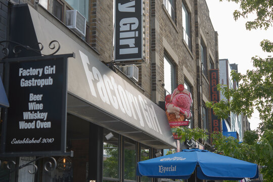 exterior building facade projecting and storefront signs outside Factory Girl, a gastropub, located at 193 Danforth Av, Toronto