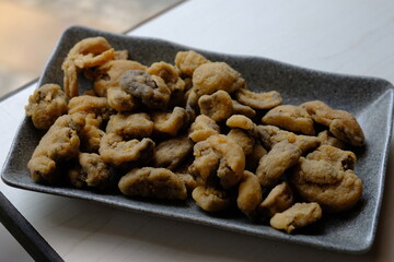 Crispy fried straw mushrooms on a gray plate. Mushrooms are a great substitute for meat.