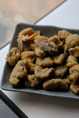 Crispy fried straw mushrooms on a gray plate. Mushrooms are a great substitute for meat.