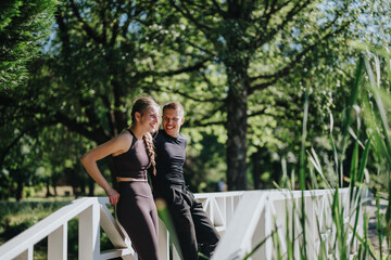 A happy couple enjoying an outdoor moment, relaxing and smiling near a scenic wooded area.