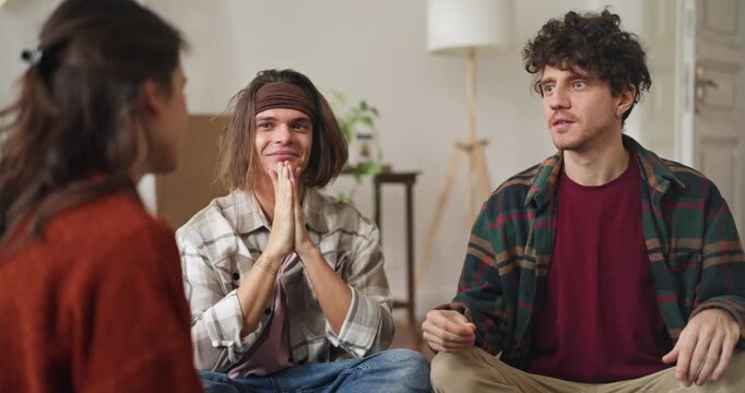 Over the shoulder Girl chatting with her friends and relaxing with snacks at home. Girl tells an interesting story and actively gestures at home