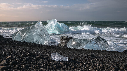 Icebergs melting on black sand beach with ocean waves crashing