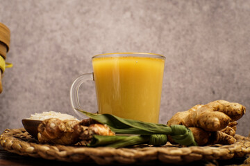 A glass of beras kencur, a traditional Indonesian herbal drink made from rice, ginger, and aromatic...