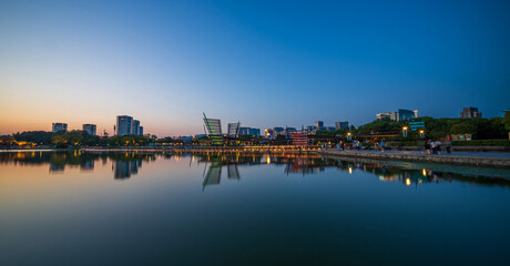 Serene Cityscape: A Stunning Sunset Reflection Over Tranquil Waters