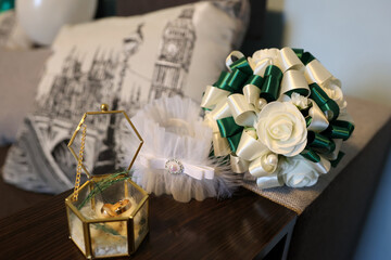Arrangement of wedding rings, garter and wedding bouquet