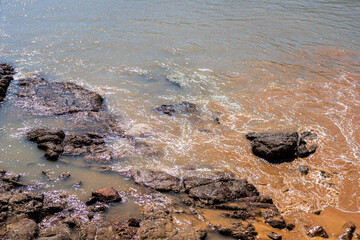 Serene Rocky Shoreline with Gentle Waves and Colorful Tones of Nature