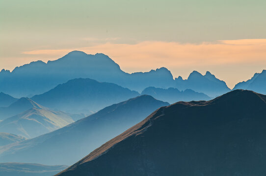 Aerial view of a serene landscape where layers of majestic mountains fade into the misty horizon, their peaks kissed by the soft glow of the morning light, Vysok&Atilde;&copy; Tatry, Pre&Aring;&iexcl;ov Region, Slovakia.