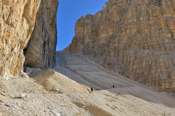 Steep hiking trail through stunning rock faces to mountain peak Sas de Pordoi. Sella mountain...