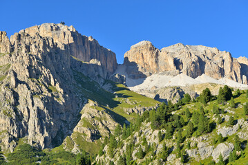 Serene dolomite mountain Sella panorama view with summit Sas de Pordoi against cloudless blue sky. Dolomites, Trentino, Italy.