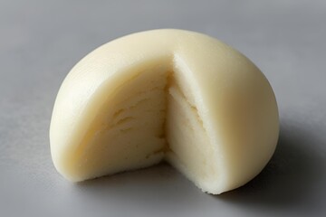 Simple Plain White Mochi with a Slice Cut Out on a Grey Background