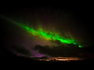 Aurora boreal through dark clouds