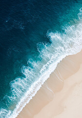Aerial view of a pristine sandy beach with turquoise ocean waves gently crashing onto the shore