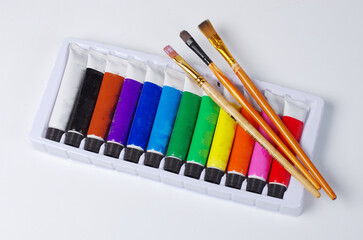 A set of oil paints for painting and three art brushes.
