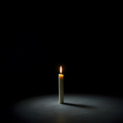a lone, slender white candle stands upright in the profound darkness, its single flame casting a small,