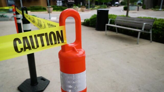A caution tape barrier blocks off a section of the sidewalk