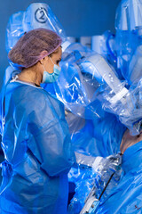 Robot-assisted surgery team at work. Medical staff in gear use robots for a precise surgery in a modern operating room.