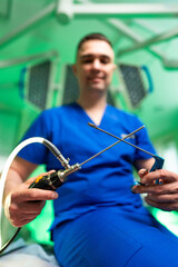 Surgeon ready for lap surgery. A medical professional in blue scrubs readies surgical tools for a...