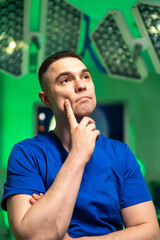 Doctor in scrubs deep in thought. A doctor in blue scrubs thoughtfully considers patient care...