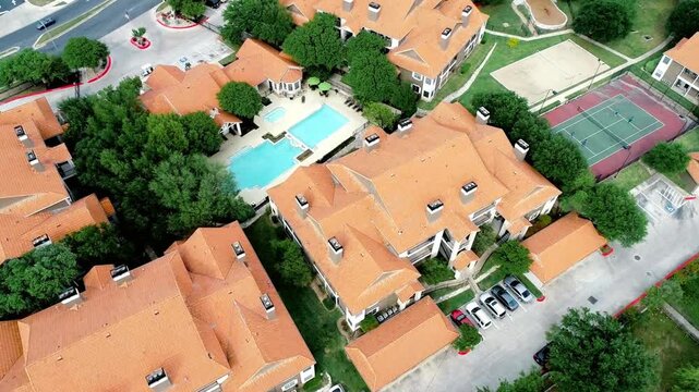 Aerial view of an apartment complex with pool and tennis court