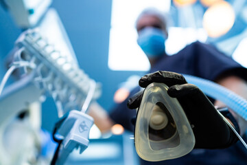 Surgical prep in a clinic. A medical professional prepares anesthesia equipment in an operating...