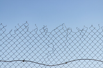 A chain link fence with a broken section