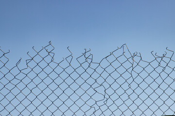 A chain link fence with a hole in it