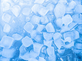 Top view of transparent ice cubes arranged neatly. Background with ice cubes. The background blue...