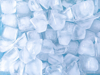 Top view of ice cubes on blue background. The background of ice cubes is blue with a fresh nuances...