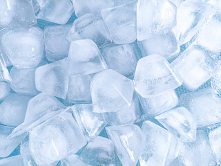 Top view of ice cubes on blue background. The background of ice cubes is blue with a fresh nuances...