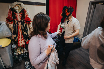 Young actors dress backstage, finalizing costumes and props, preparing for their theatrical...