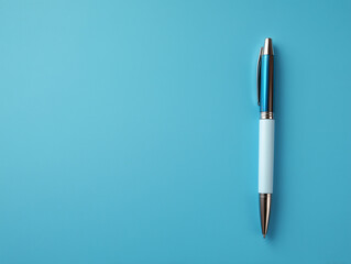Blue ballpoint pen standing vertically on blue background