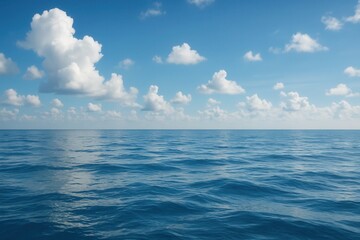 Obraz premium A Serene View of Endless Blue Waves Under a Sky of Fluffy Clouds