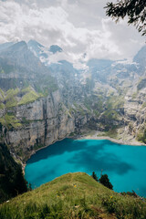Crystal-Blue Oeschinensee Amid Snow-Capped Alpine Giants, Majestic Turquoise Lake Nestled Among Towering Mountains